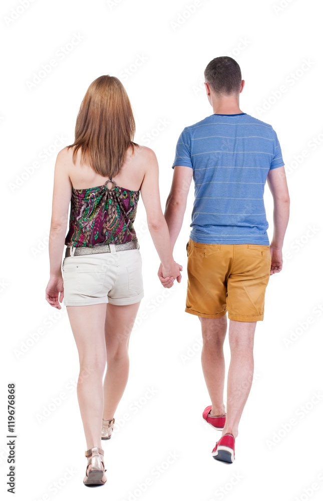 Back view going couple in shorts. walking friendly girl and guy holding hands. Rear view people collection. backside view of person. Isolated over white background. Back view going couple in shorts. walking friendly girl and guy holding hands. Rear view people collection. backside view of person. Isolated over white background.