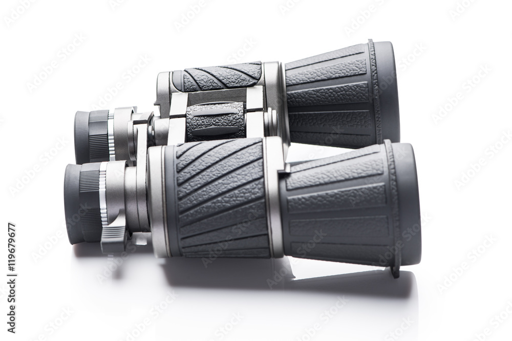 Single black pair of binoculars isolated on a white background. Single black pair of binoculars isolated on a white background.