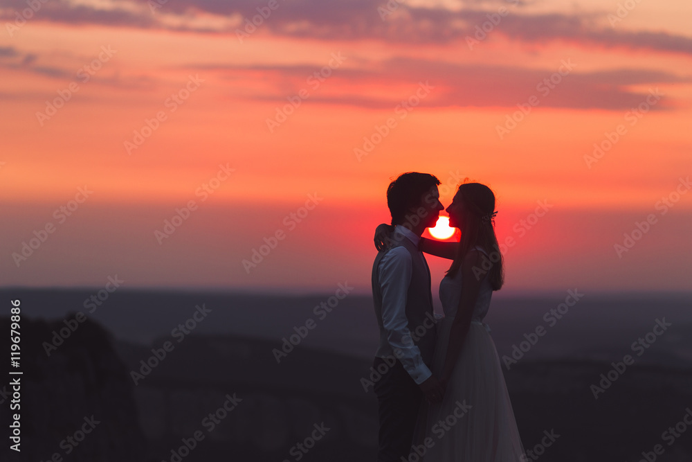 Bride and groom at beautiful sunset in the mountains