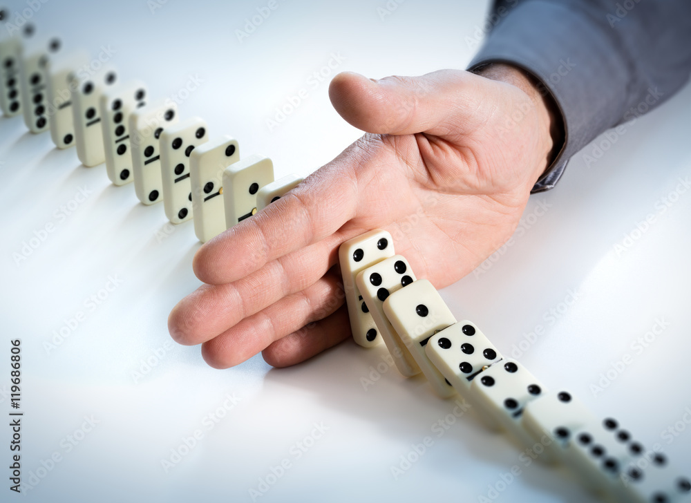 Fotografie Stop Domino Effect - Hand Prevents Failure
