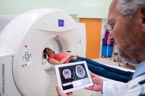 Doctor looking at brain mri scan on digital tablet photo