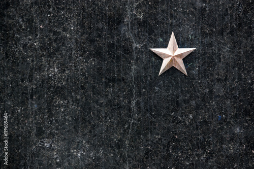 gold star on a black granite surface (headstone)