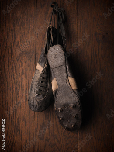 Old used sports shoes on a rustic wooden wall