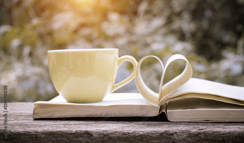 Pages of a book curved into a heart shape.heart of the book.coffee background,old book page decorate to heart shape for love in valentine day. Pages of a book curved into a heart shape.heart of the book.coffee background,old book page decorate to heart shape for love in valentine day.