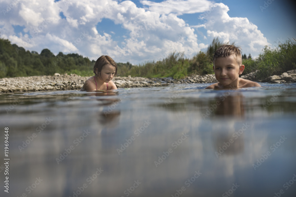 Fototapeta premium Kids swimming in the river during the holiday, summertime