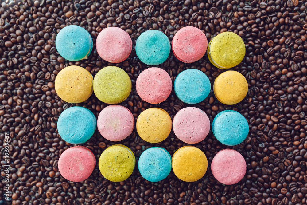 Sweet and colourful french macaroons on coffee beans background