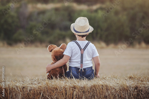 niño abrazado a su oso de peluche photo