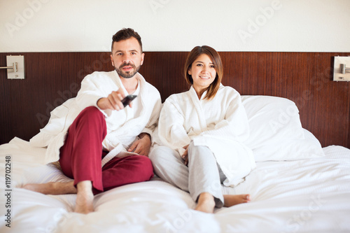 Cute couple watching TV at a hotel