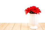 Red daisy flower in pot on wood texture isolated on white backgr