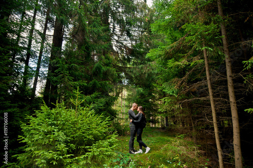 Attractive young couple hug in forest