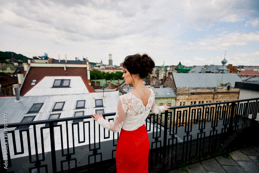 Young girl is standing on the balcony