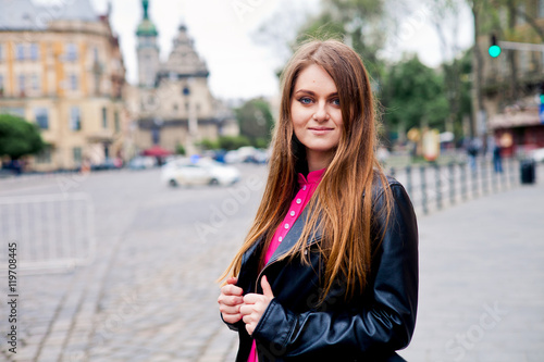 Blue eyed young girl in black jacket in city