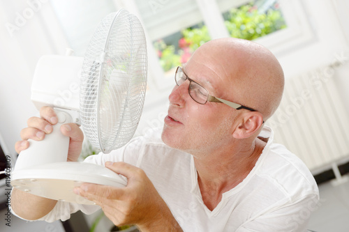 mature man refreshed with a fan