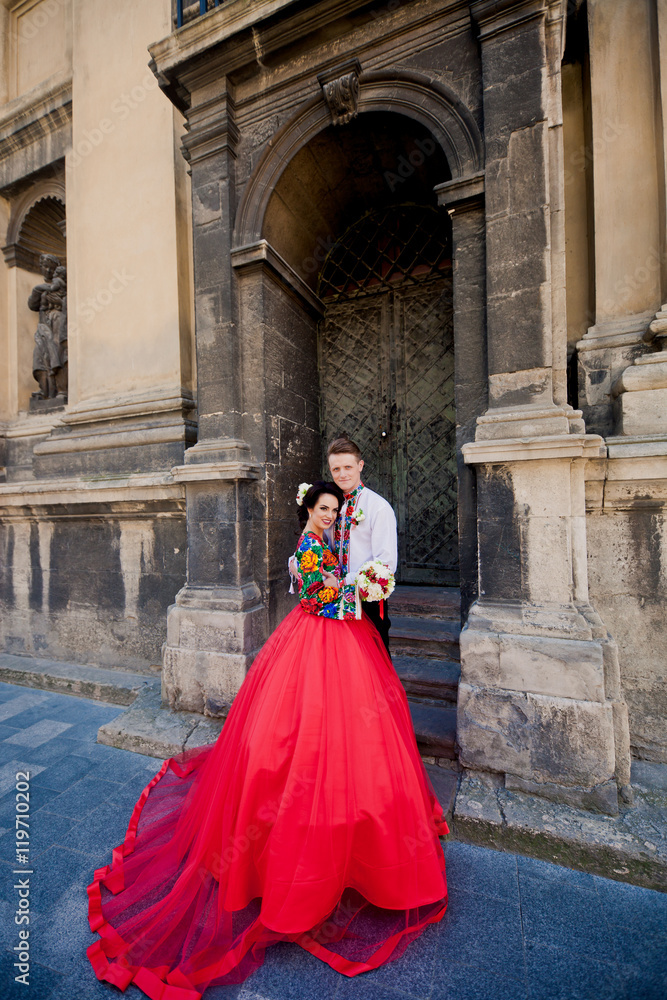 Amazing wedding couple near old church's entrance