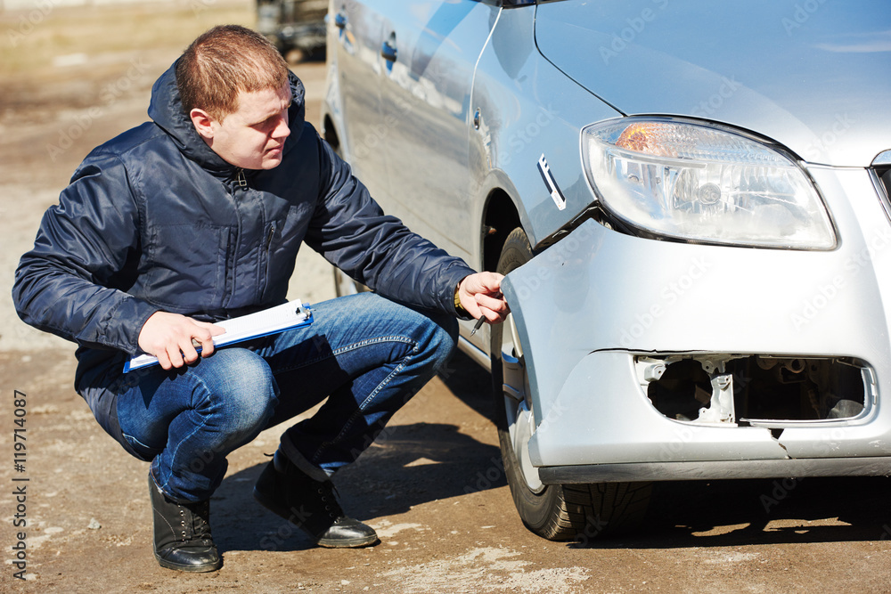 Insurance agent recording car damage on claim form Insurance agent recording car damage on claim form