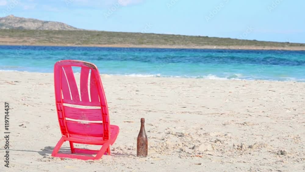 red plastic chair in a desert beach in Sardinia red plastic chair in a desert beach in Sardinia