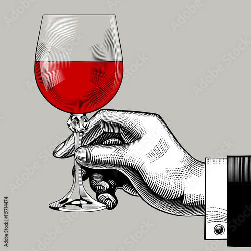 Hand holding a glass with red wine