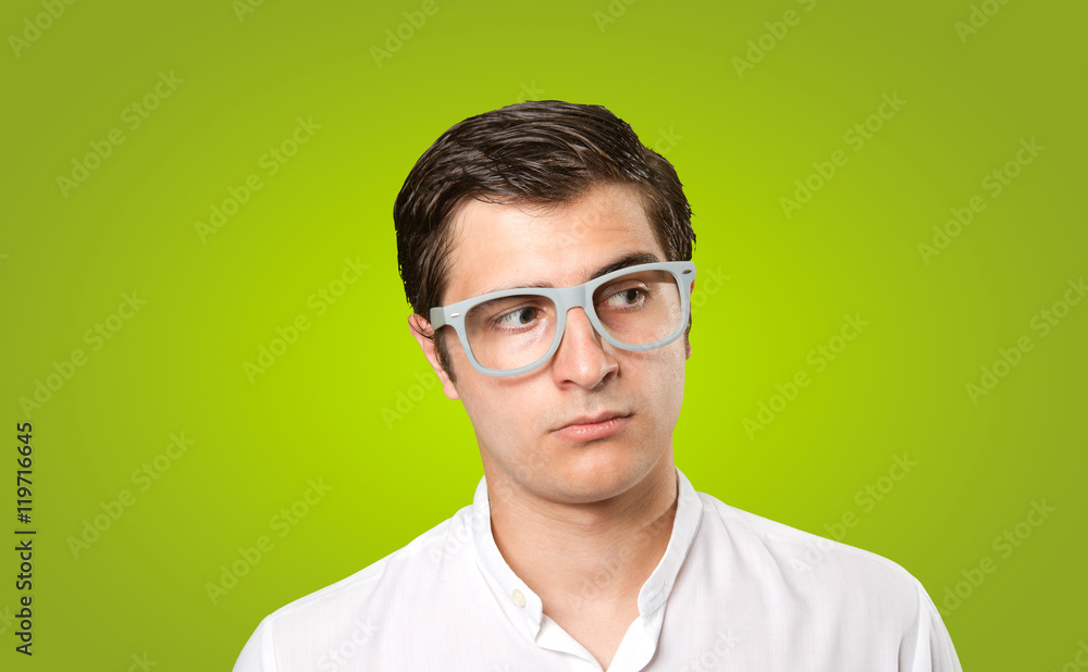 Close up of a thoughtful young man on green background Close up of a thoughtful young man on green background