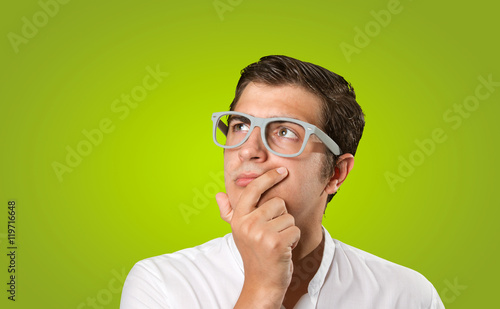 Close up of a young man wondering on green background