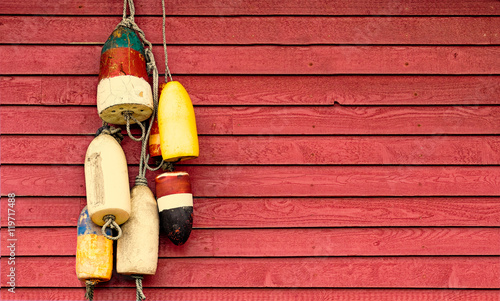 Vintage lobster floats on old red wood siding background. Nautical 