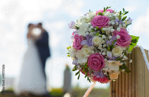 Couple kissing on the background of a wedding bouquet. Blurred s