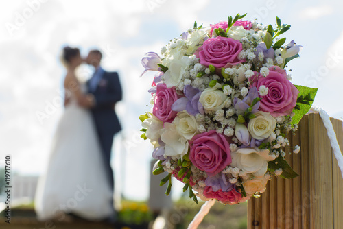 Couple kissing on the background of a wedding bouquet. Blurred s