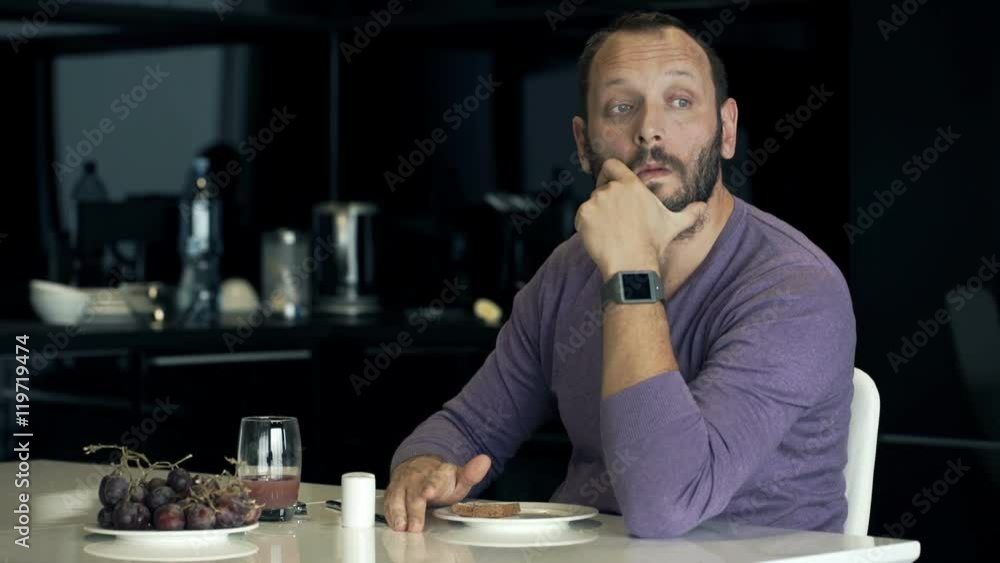 Sad, unhappy man drinking juice by table in kitchen at home
Sad, unhappy man drinking juice by table in kitchen at home