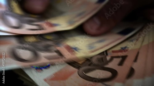 Businessman’s hands counting euro bills in darkness photo