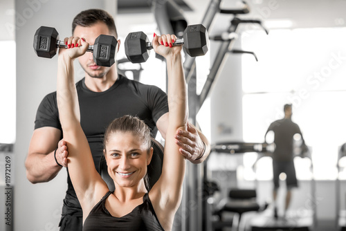 Woman doing fitness with personal trainer help.