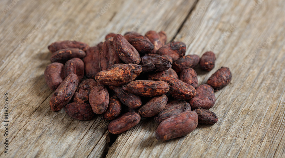 Cocoa beans on a wooden surface Cocoa beans on a wooden surface