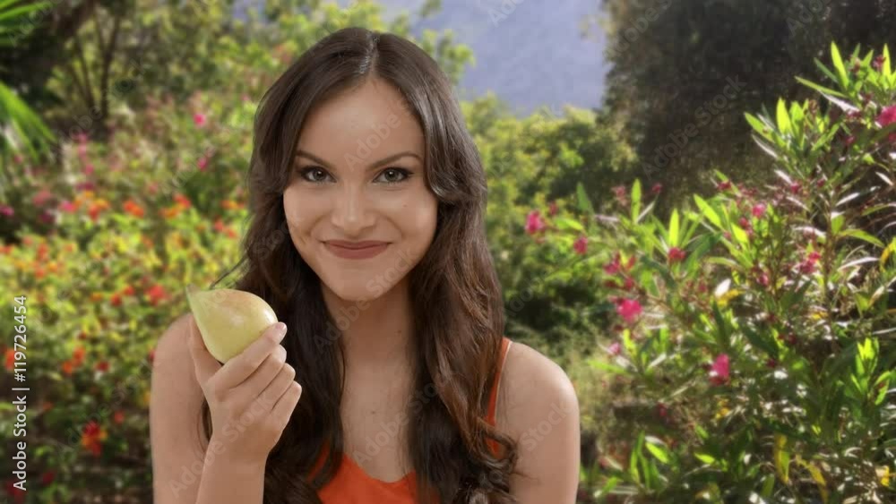 Young woman eating pear in garden Young woman eating pear in garden