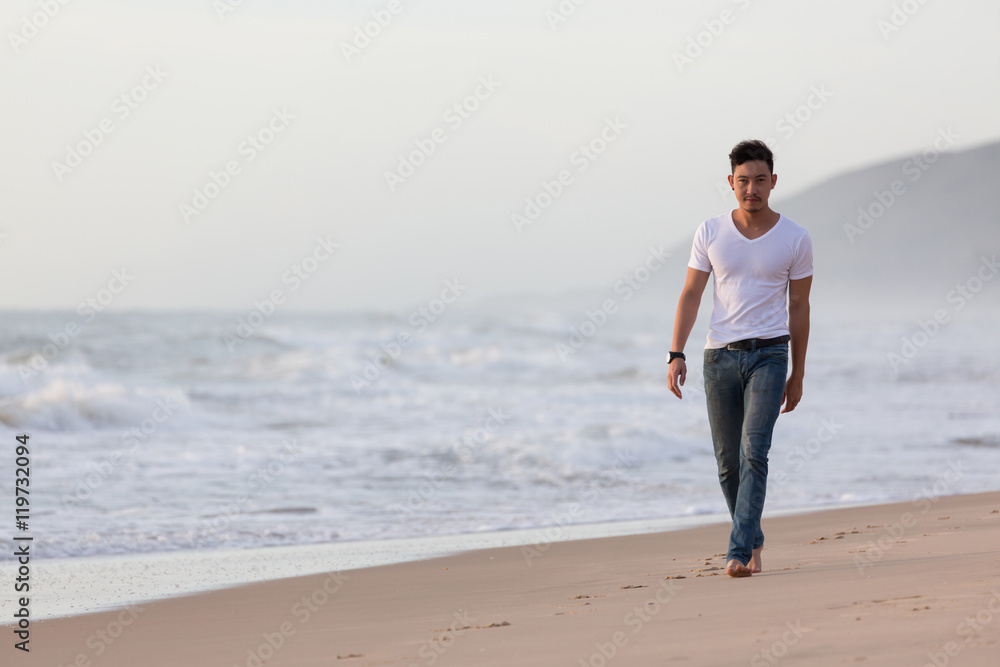 fashion model man walking on the sand beach, beautiful sea