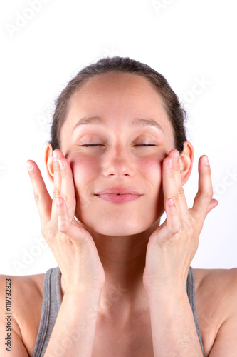 Young attractive woman applying cream on her skin