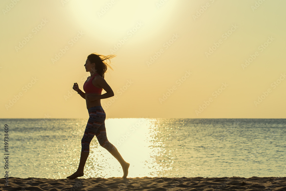 Girl runs along the beach at sunset