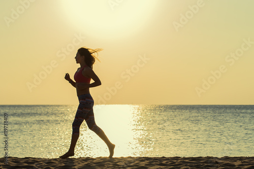 Girl runs along the beach at sunset