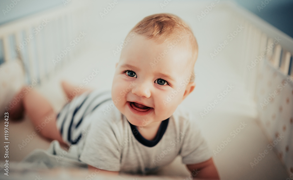 Exhausted tired baby boy kid smiley smiling close up big eyes in the bed the natural summer sun Exhausted tired baby boy kid smiley smiling close up big eyes in the bed the natural summer sun
