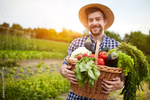 Man holding basket with organic vegetables
