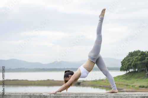 Woman practicing Yoga Horse Rider Yoga Pose in the morning