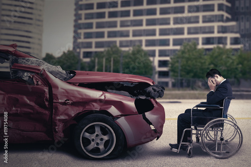 Disabled person and damaged car © Creativa Images