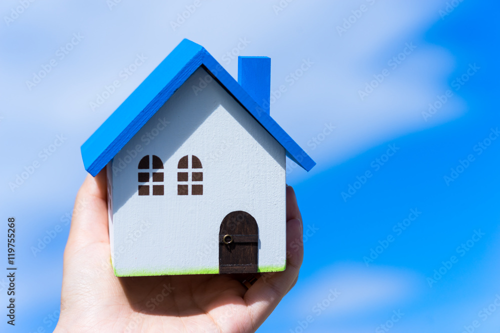Home image, blue house toy in hands Home image, blue house toy in hands
