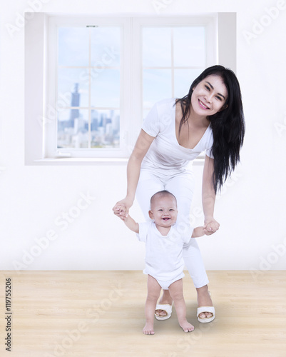 Mother helping baby learn to walk