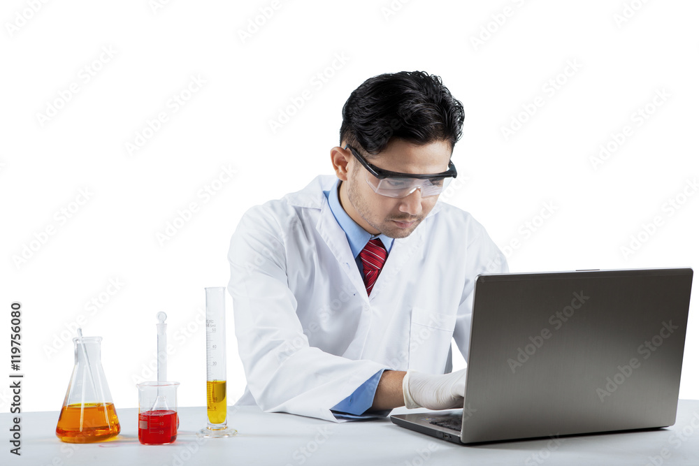 Scientist working with laptop and chemistry Scientist working with laptop and chemistry