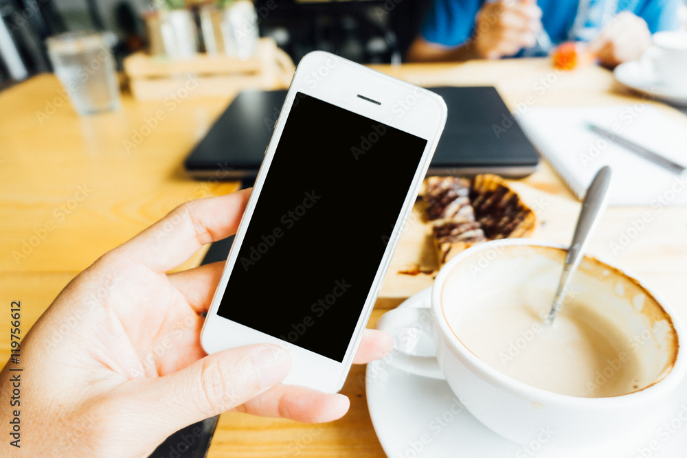 Man using blank smartphone with coffee and dessert