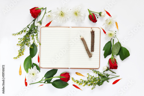 flowers and open blank notebook on white background