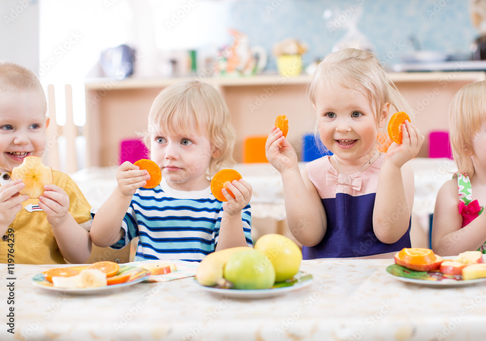 funny kids eating fruits in kindergarten dinning room funny kids eating fruits in kindergarten dinning room