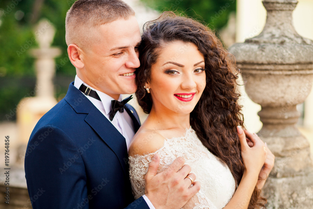 Smiling curlyhaired  bride in amazing dress with her husband