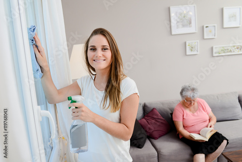 Foto cheerful young girl helping with household chores elderly woman at home