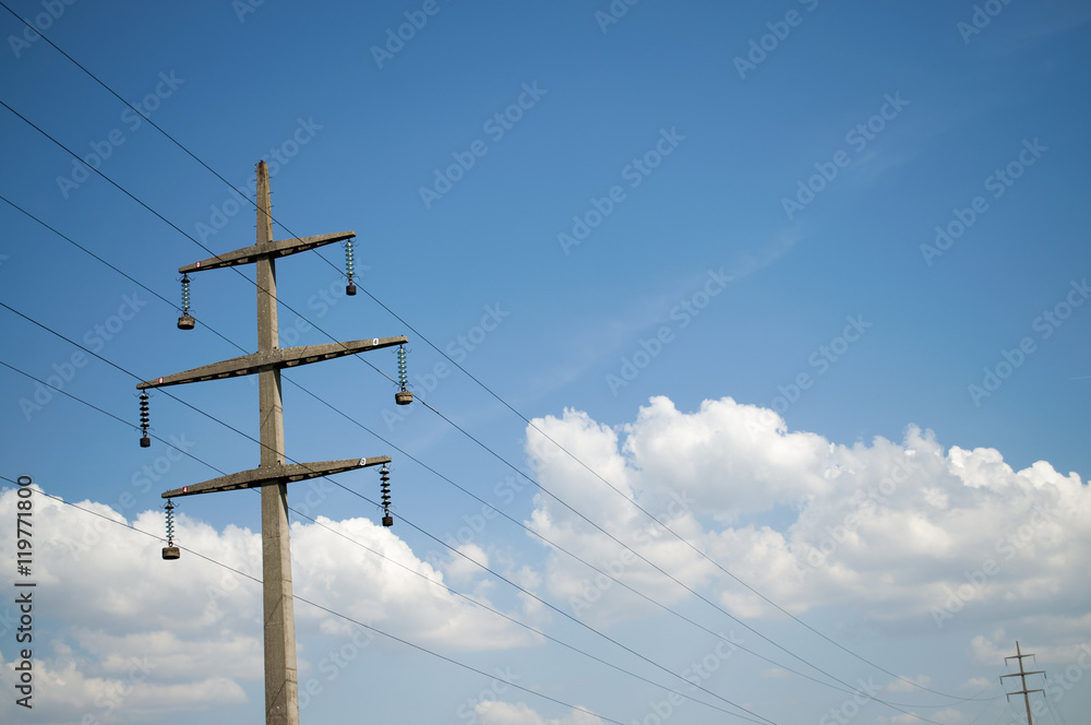Concrete electric pillar against blue sky with nice clouds Concrete electric pillar against blue sky with nice clouds