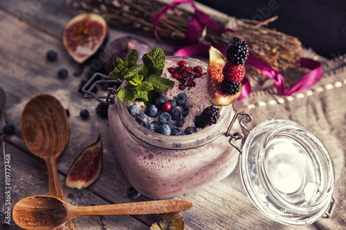 bright detox smoothie with berries on wooden background bowl