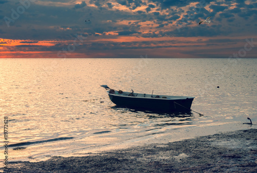 Coastal landscape with lonely fishing boat  Baltic Sea at sunrise